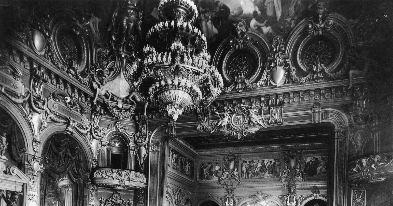 Bogato zdobione wnętrze zabytkowego teatru operowego z widownią, lożami i sceną.